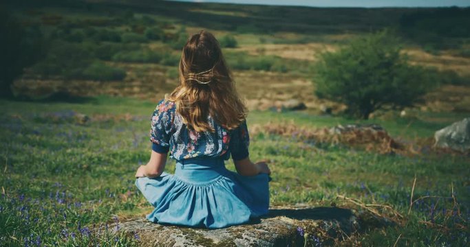 Young woman meditating on the moor