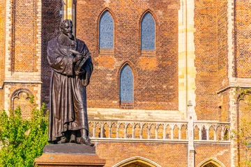 Deurstickers Statue of Hugo Grotius in front of Niuewe Kerk in Delft, Netherlands © dudlajzov