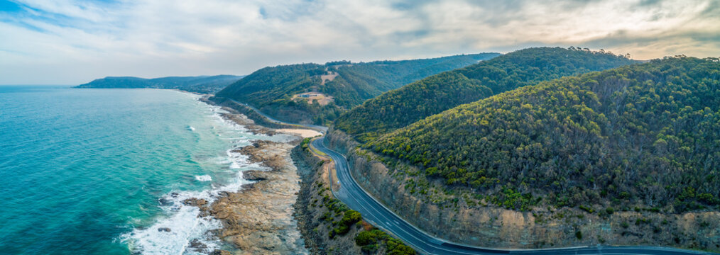 Great Ocean Road passing through scenic landscape in Victoria, Australia - aerial panoramic landscape