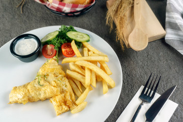 Scrambled eggs or omelette made from eggs and cheese with herbs on the plate