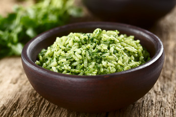 Traditional Mexican Arroz Verde green rice dish made of long-grain rice, spinach, cilantro and garlic, served in rustic bowl (Selective Focus, Focus in the middle of the image)