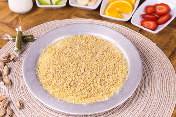 Turkish dessert kunefe, kunafa, kadayif with pistachio powder and cheese hot eaten a sweet