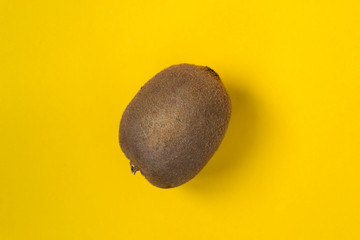 Whole kiwi fruit isolated on yellow background. Clipping path Full depth of field