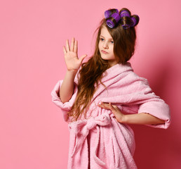 Exacting young girl teen lady with curlers in hair in bathrobe shows Wait a second sign gesture....