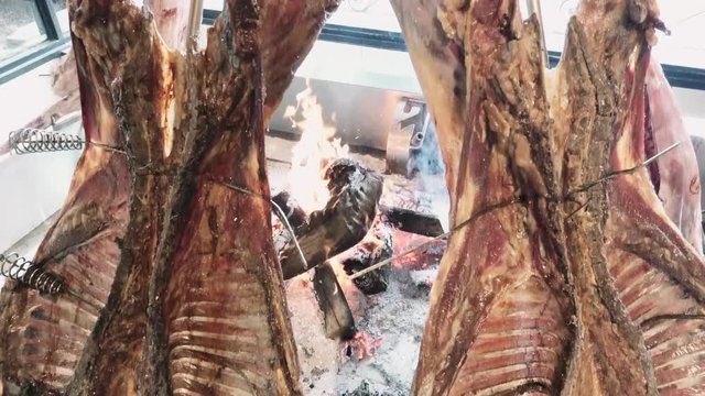 Traditional Argentinian asado roasted lamb grilled meat. Patagonia, Argentina. 4k
