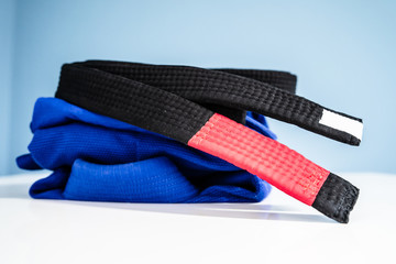 BJJ Brazilian Jiu JItsu Black Belt and blue kimono gi on the table at home