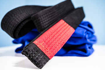 BJJ Brazilian Jiu JItsu Black Belt and blue kimono gi on the table at home