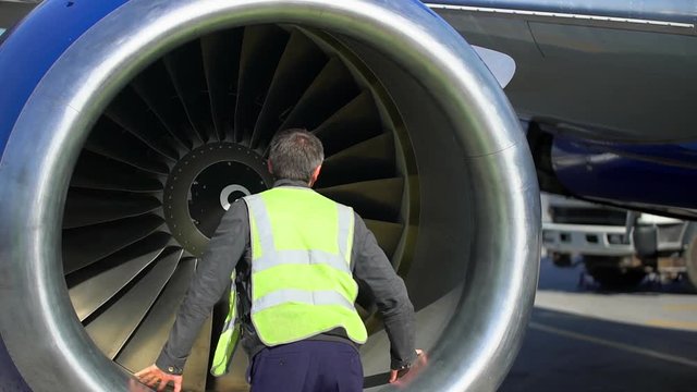 Airport. Aircraft mechanic worker inspecting jet turbine engine blades on runway. employee supervisor maintenance ground inspection checking aircraft airplane, departure quality control flight safety
