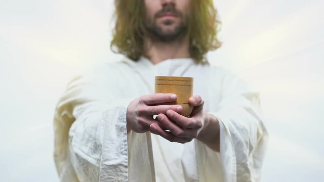 Merciful Jesus reaching out hands with wooden glass giving fresh water to people