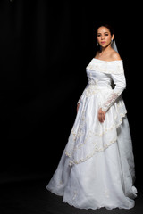 Fototapeta premium Lovely Asian Beautiful Woman bride in white wedding gown dress with lace veil, black hair, studio lighting black gradient background isolated copy space, sweet romantic soft alone bridal concept