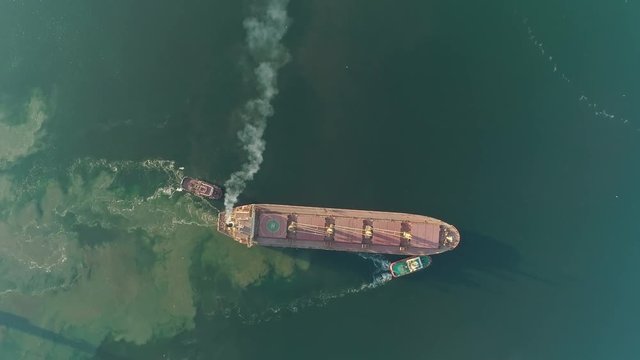 Air pollution by sulphur SOx and nitrous oxides NOx from big cargo ship diesel engine, aerial top down view. MARPOL