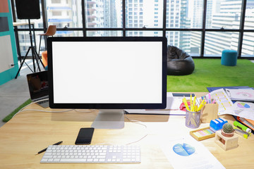 modern office with computer on wood desk, office supplies and coffee cup (focus on cactus)