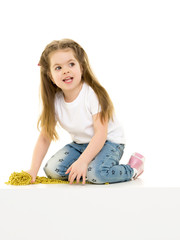 Little girl is sitting on the floor.