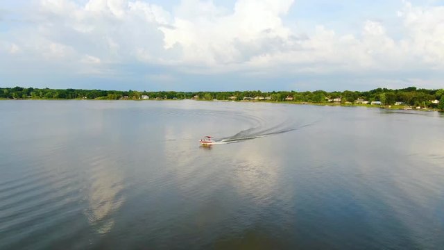 Boat circling a quiet Central Florida lake on a spring evening