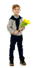 Little boy with a bouquet of flowers tulips.