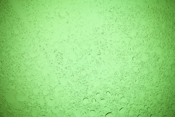 Rain droplets on green glass background, Water drops on green glass.