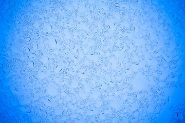 Rain droplets on blue glass background, Water drops on blue glass.