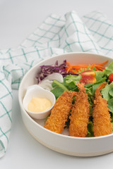 Close up crisp deep-fried prawns with salad in white bowl