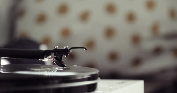 Turntable vinyl record player on blur background in the old interior. Retro audio equipment for disc jockey, closeup view.