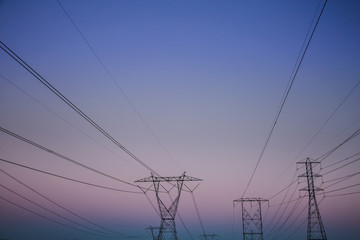 Electric Power Lines over a Desert at Sunset