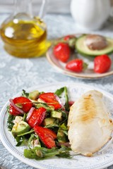 food without carbohydrates - fried chicken breast and salad with strawberries, cheese, avocados, onions and herbs, dressed with oil and balsamic. keto diet. rich in proteins. lunch for keto.