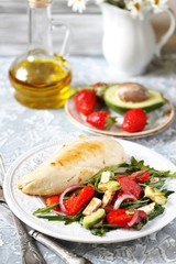 food without carbohydrates - fried chicken breast and salad with strawberries, cheese, avocados, onions and herbs, dressed with oil and balsamic. keto diet. rich in proteins. lunch for keto.