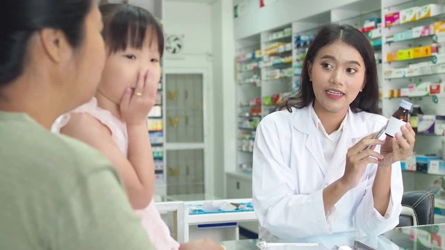 Beautiful asian Pharmacist explaining the medication to patient in drug store