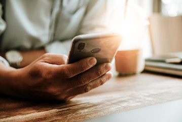 Man using smart phone mobile for connect with friends in coffee shop