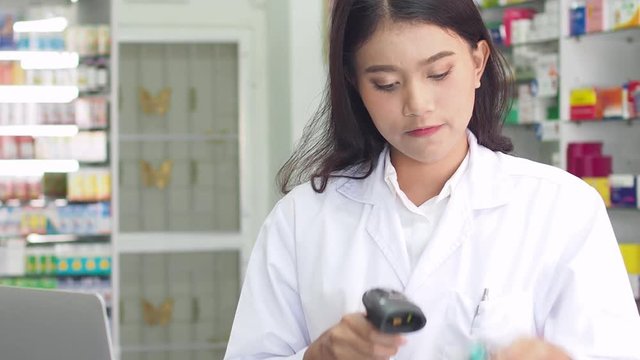 Beautiful pharmacist scanning for checking drug stock in drugstore