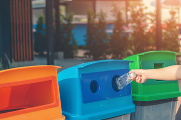 Fototapeta premium Dump the garbage into the blue tank for recycling.