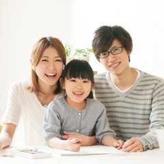 お絵描きをする女の子と両親