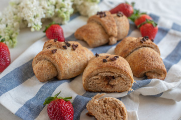 Homemade fresh golden croissants with strawberries and white lilac 
