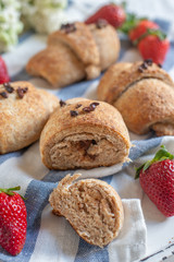 Homemade fresh golden croissants with strawberries and white lilac 