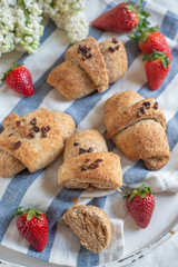 Homemade fresh golden croissants with strawberries and white lilac 