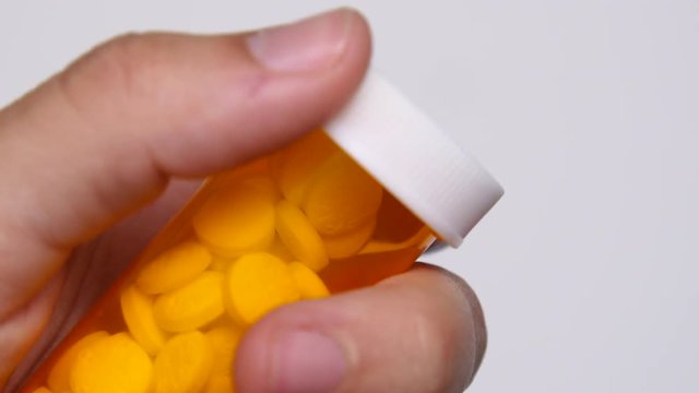 Person handles bill bottle on white background.