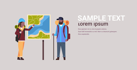couple of tourists hikers with backpacks looking at travel map african american man woman planning the route hiking concept travelers on hike horizontal full length copy space flat