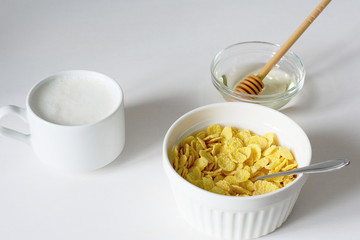 Healthy breakfast with cornflakes and milk over white background