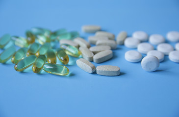 capsules and pills on a blue background, copy space