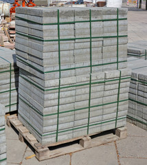 Stacks of new concrete paving slabs on  wooden pallet