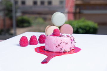 elegant berry tart, colorful macaroons and fresh berries. Blurred background