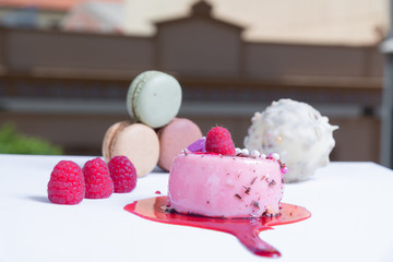 elegant berry tart, colorful macaroons and fresh berries. Blurred background