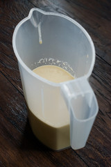 Raw Pancake Dough in Plastic Carafe Ready to Pour on Pan.