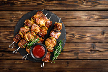Grilled meat skewers, shish kebab on wooden background, top view