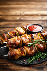 Grilled meat skewers, shish kebab on wooden background