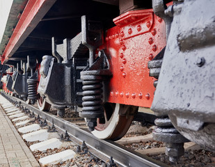 Steel wheels old steam locomotive standing on rails, vintage train, close-up