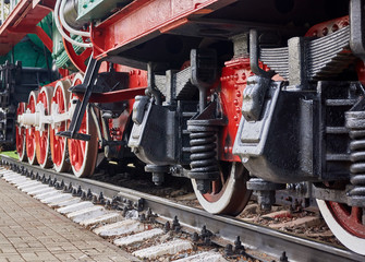 Steel wheels old steam locomotive standing on rails, vintage train, close-up