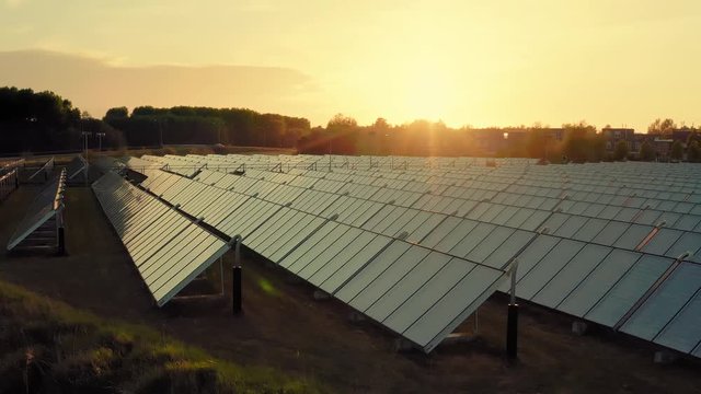 Aerial panning shot of solar panel array generating green energy for a sustainable neighbourhood in Almere, The Netherlands. Light reflecting from the surfaces of the panels.