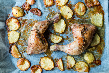 Two Grilled Chicken Legs with Baked Potatoes in Oven Tray.