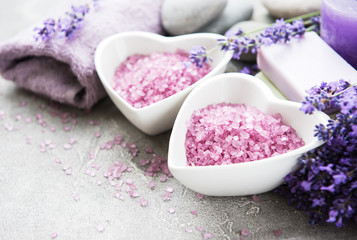 Fototapeta na wymiar Heart-shaped bowl with sea salt, soap and lavender flowers