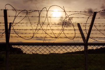 Metal fence wire, War and sky in the background Silhouette in Phuket Thailand